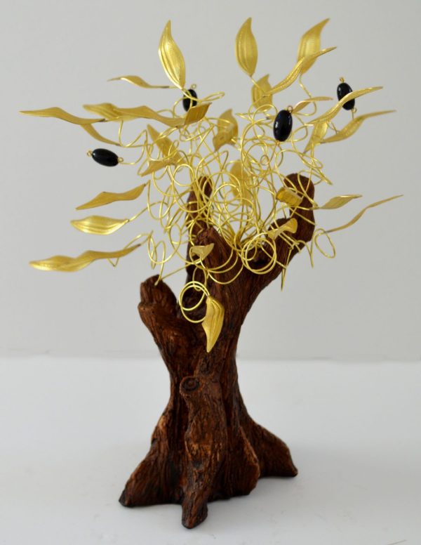A bronze statue of an olive tree with a brown base, gold leaves and black olives on a white background.