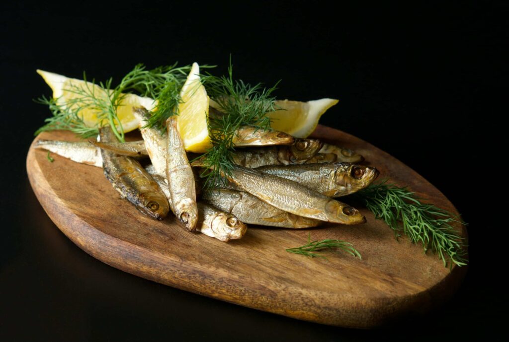Sardines grillées servies avec citron et aneth, spécialité grecque traditionnelle.