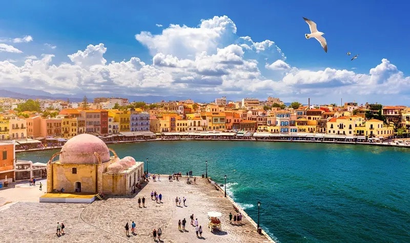 Panoramic view of Chania, Greece, showcasing its Venetian port, colorful houses and blue skies