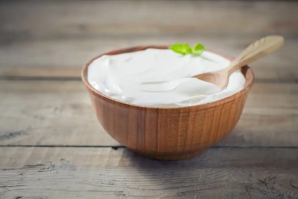 Greek yogurt with mint in a wooden bowl