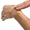 Close-up of a hand applying a rich, creamy balm