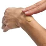 Close-up of a hand applying a rich, creamy balm