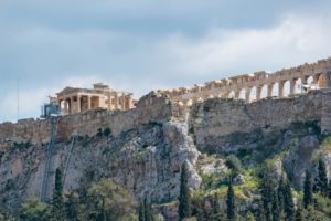 View of the Acropolis of Athens with the Parthenon on a rocky hill under a cloudy sky. Growy and Tasty