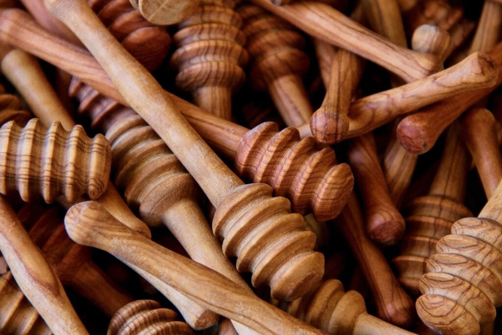 Cuillères à miel en bois d’olivier grec, montrant les motifs distinctifs du bois.