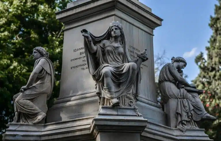 Statues en bronze représentant des figures antiques, avec des inscriptions gravées.