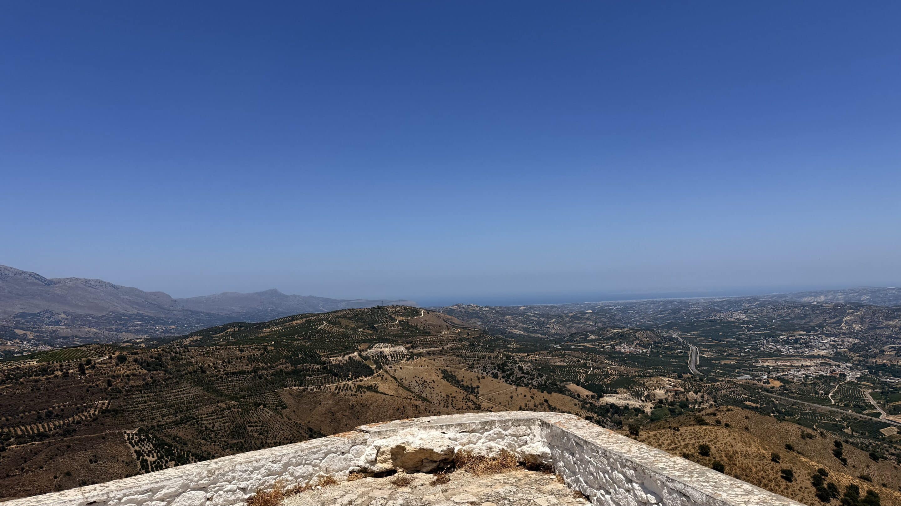 Panorama sur les collines et oliveraies de Crète depuis un promontoire en pierre