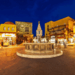 Vieille ville de Rhodes de nuit – place animée et fontaine médiévale