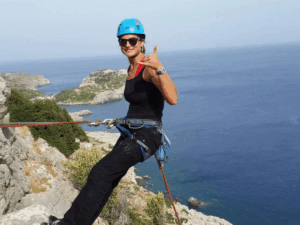 Escalade à Rhodes avec une participante sur falaise.