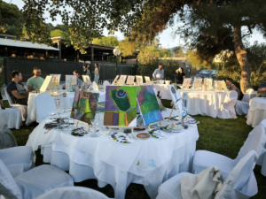 Open-air painting workshop in Athens with exhibited canvases and participants