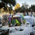 Atelier de peinture en plein air à Athènes avec toiles colorées exposées sur les tables