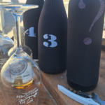 Degustazione alla cieca di vini cretesi e raki con bicchieri e bottiglie mascherati su una terrazza a Chania, Creta.