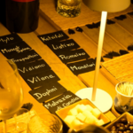 Etichette di vino cretese su un tavolo con cubetti di formaggio e olive da degustare a Chania, Creta.