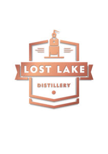 Logo Lost Lake Distillery - simbolo di distillazione stilizzato sopra il testo "Lost Lake Distillery" in sfumatura rame, incorniciato da una fascia e da forme geometriche