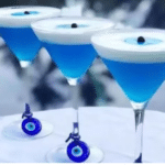Cours de cocktails grecs à Égine avec cocktails bleus et symbole œil grec.