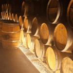 Chai de vieillissement de vins bio en Crète avec fûts en bois alignés, illustrant une expérience viticole immersive.