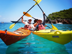 Excursion en kayak à Agistri, mer turquoise et île verdoyante en arrière-plan.