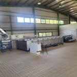 Intérieur d'une huilerie en Crète avec machines industrielles pour l'extraction de l'huile d'olive, illustrant le processus de production.