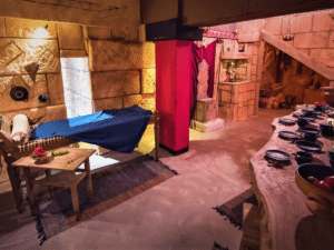 Salle des vignerons reconstituée à Athènes pour une expérience œnologique antique, avec tables et accessoires de dégustation.