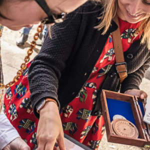 Participants discovering an escape game on the theme of Archimedes in Athens, observing clues and a disc engraved with symbols.