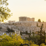 Vue de l'Acropole et du Parthénon à Athènes depuis un point de vue pittoresque, entouré de végétation.