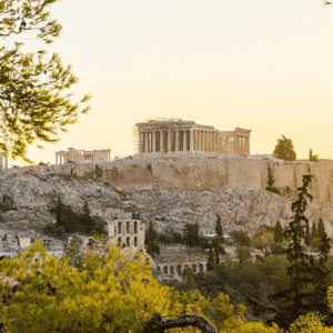 View of the Acropolis and Parthenon in Athens from a picturesque vantage point, surrounded by vegetation.