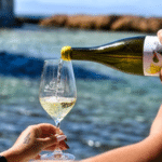 Verre de vin blanc crétois servi lors d’une dégustation au bord de l’eau à La Canée, Crète